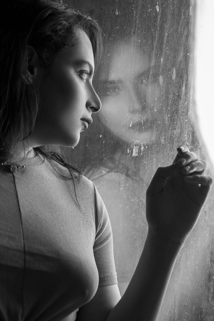 woman in window looking to the rain, black white photo