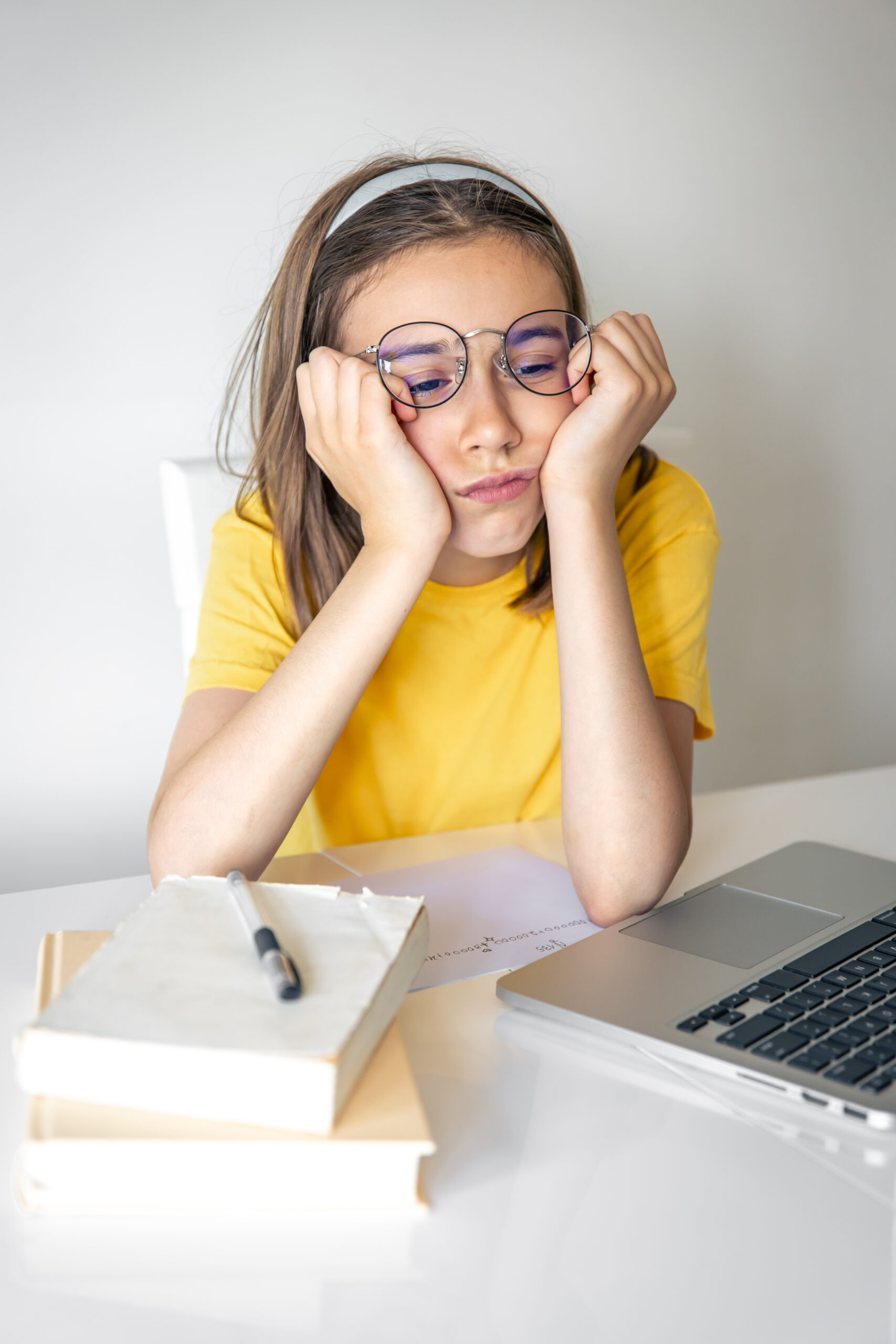 exhausted schooler girl suffering from doing homework, tired from studying.