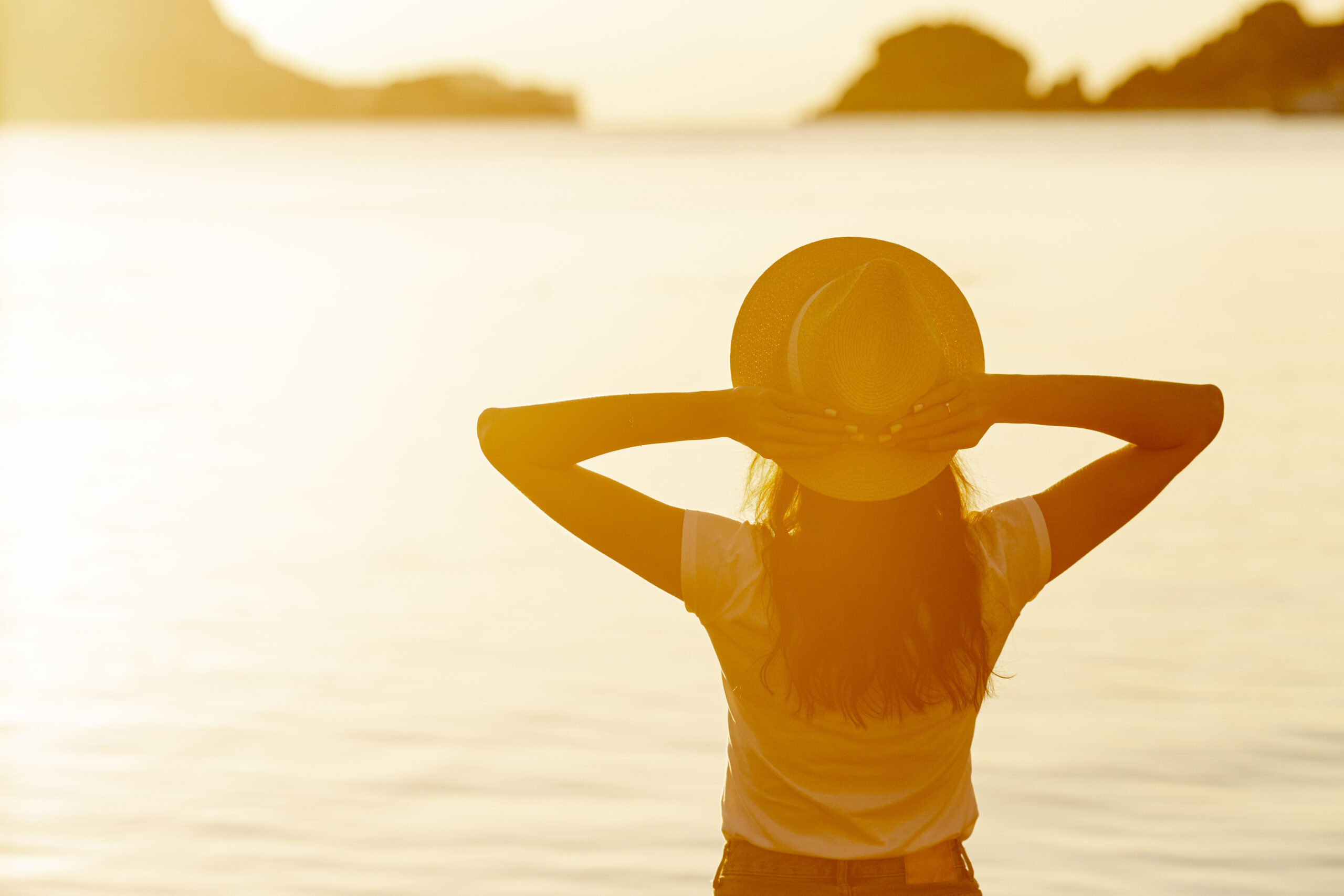 woman with hat sunset shore lake