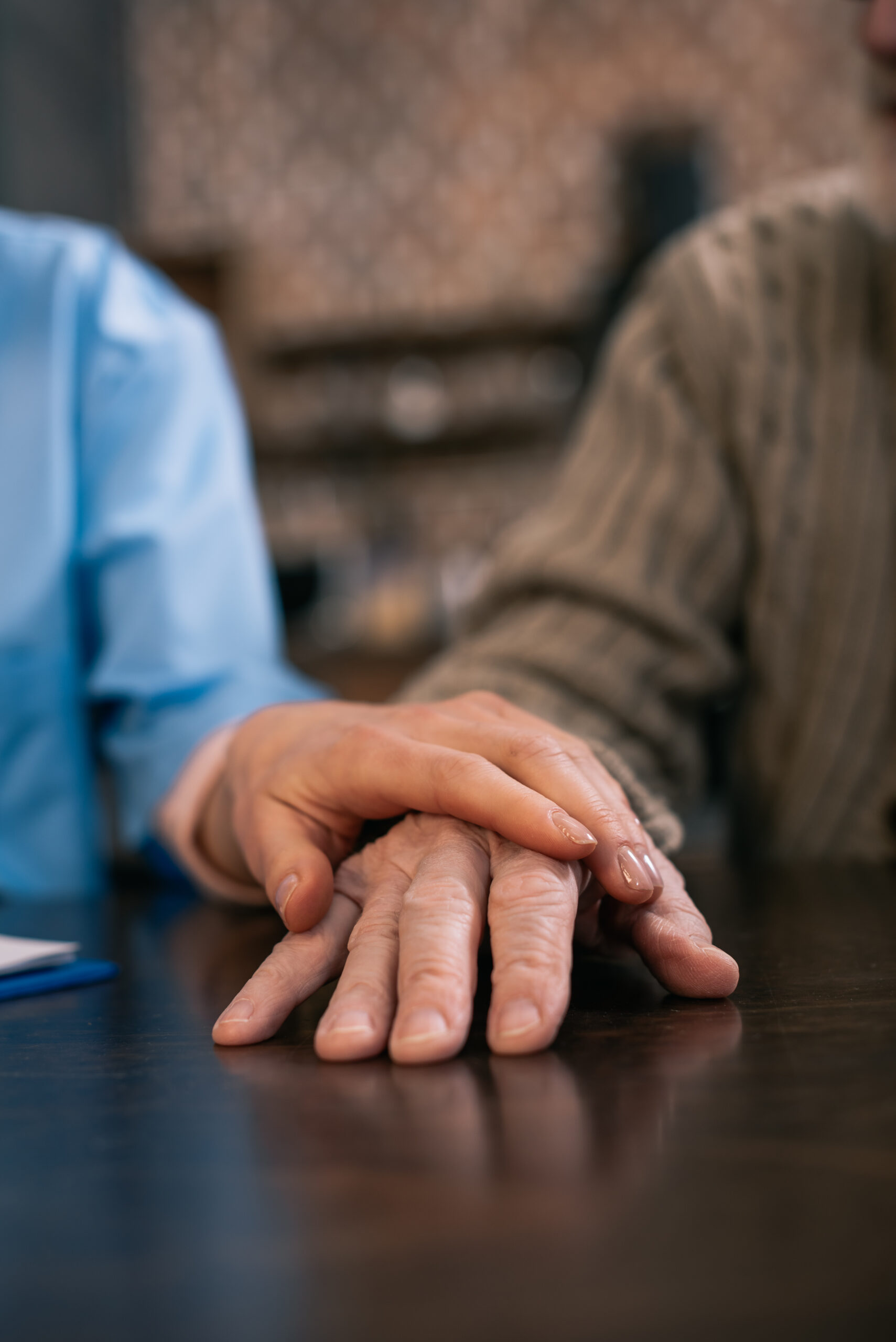 caregiver supporting and holding hand of senior man