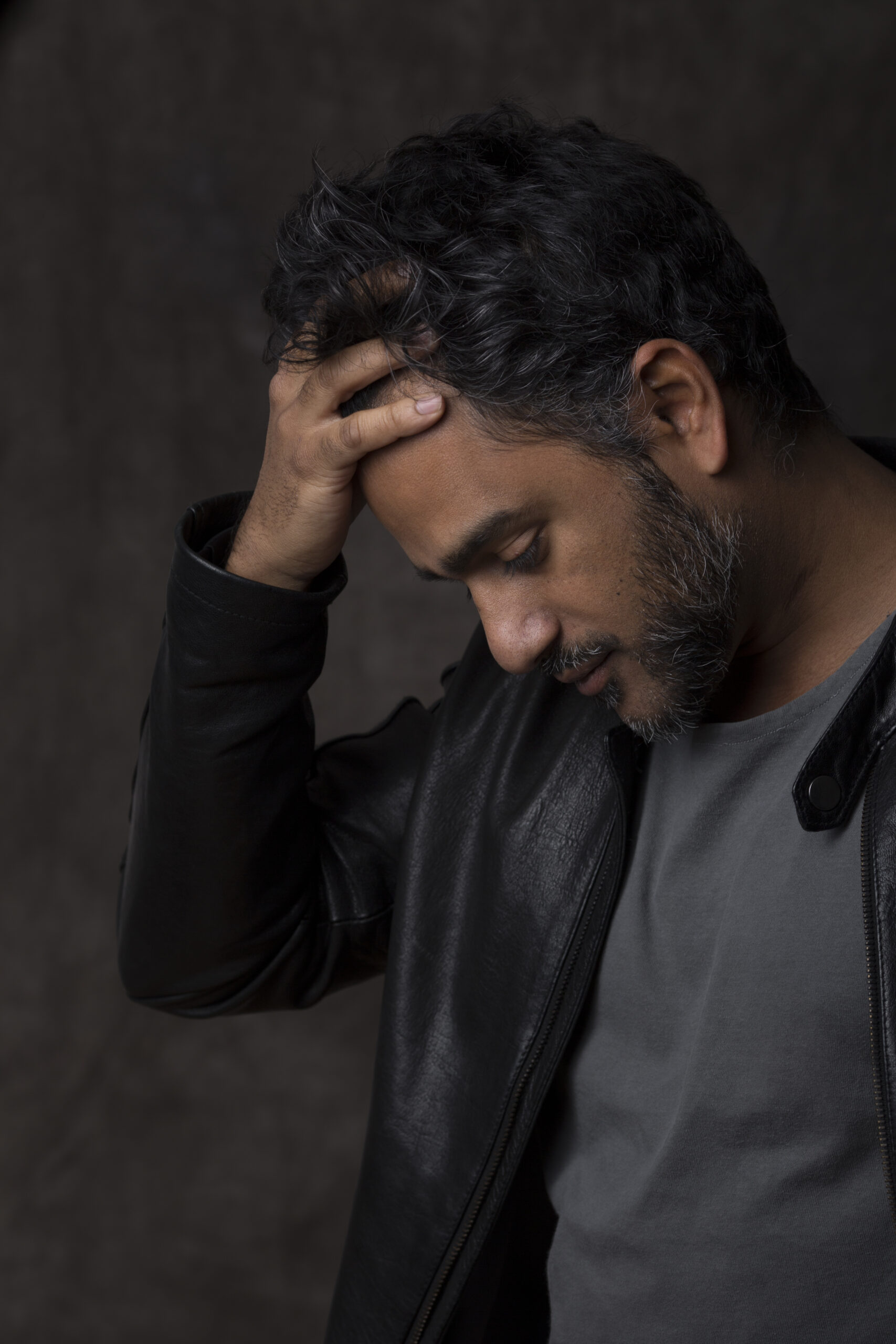 portrait of an indian man, holding his head